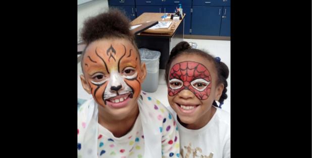 CCISD/COURTESY PHOTO - Clements/Parsons Elementary Malaiyuh Floyd Walters and Assiya Turner show off their freshly painted faces with Walters as a lion and Turner as Spiderman. The two girls each earned 100 Bee Bucks, a school currency for good behavior,