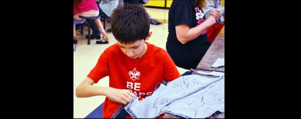 CCLP/DAVID J. HARDIN - Sixth Grader Matthew Petty helps cut jeans at Sole Hope cutting party held last Saturday at the Copperas Cove High School.