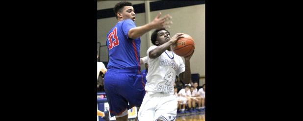 CCLP/TJ MAXWELL - Copperas Cove junior Tyrese Cooley drives through the lane past Midway senior Bubba Furlong for a traditional three-point play to help the Dawgs take a 30-29 lead in the first half of their 63-49 loss to Midway in the season finale. Despite the loss, the Bulldawgs wrapped up the fourth spot in the playoffs where they will face No. 2 Cedar Park at 7 p.m. Tuesday at Glen Rose High School.