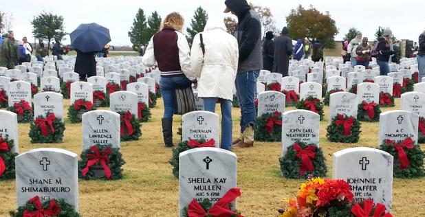 CCLP/FILE ART - Volunteers pause at a grave during last years wreath laying ceremony at the Central Texas State Veterans Cemetery. This year Marty Smith is looking for 300 volunteers to help lay 2,300 wreaths.