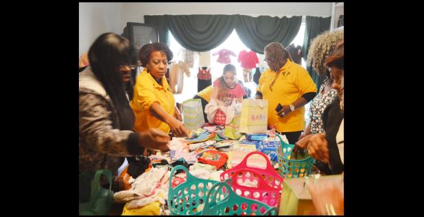 CCLP/LYNETTE SOWELL - Volunteers from the Women’s Army Corps Veterans Association sort through baby items as they make baskets for mothers-to-be at the Hope Pregnancy Center.