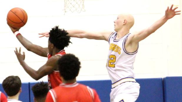CCLP/TJ MAXWELL -- Cove senior Wyatt Behara attempts a block as Harker Heights senior Davon Clare scores on a reverse layup during the Knights’ 59-52 win over the Dawgs on Friday.