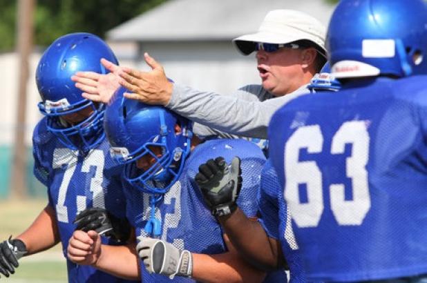 Offensive line coach Tracy Ranes gives instruction to his squad during practice Wednesday at the Copperas Cove athletic complex. The Bulldawgs get their first live action against another team when they scrimmage the Abilene Eagles today. The varisty plays at 11 a.m. with the JV on at 1:30 p.m. and the freshmen finishing up at 2:45 p.m.
