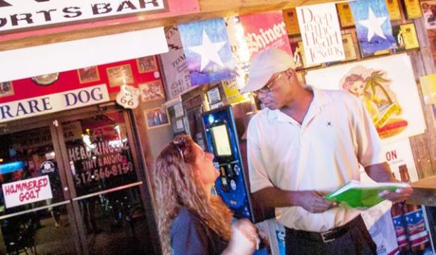 Mitch Lofton, a member of Progress Cove, picks up the final pages of the liquor petition from Monica Jensen Sunday evening at Dave’s Sports Bar as he prepares a final count before turning the petition in to the City Secretary on Monday.