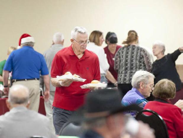 Exchangite Frank Seffrood delivers meals to more than 100 seniors who attended the annual appreciation luncheon.