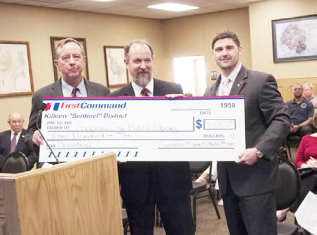 Copperas Cove Librarian Kevin Marsh, center, accepts a check for $500 from First Command Financial Planning in Killeen to be used for the purchase of new books.