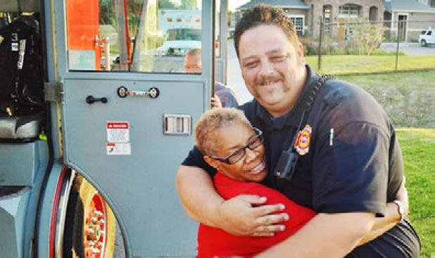 Cindy Williams gives hugs Monte Priest at Tuesday night’s National Night Out block party at Brookview Village. 