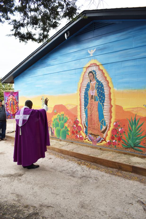 CCLP/PAMELA GRANT  Father Augustine blesses the Our Lady of Guadalupe mural outside of Holy Family Catholic Church.