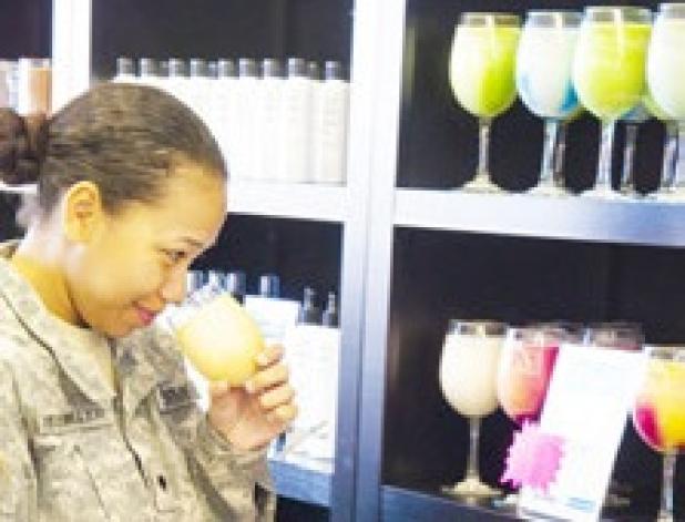 Spc Brucemiller smells the scent of one of the new I am Soy Candles at the ribbon cutting Tuesday.