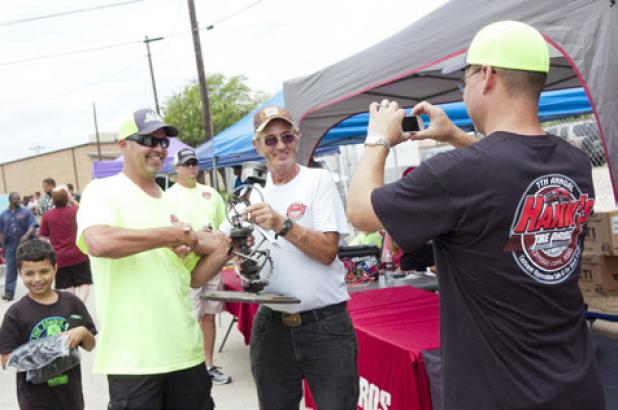 Brad Harwell, left, presents Bud Strutz with his customized trophy after his 1963 Ford Fairlane was voted as the top car in the annual car show.