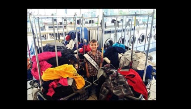 Zachary Petty, Junior Mister Rabbit Fest, stands among the carts of clothing he collected from CCISD campuses’ lost and found to donate to the needy.