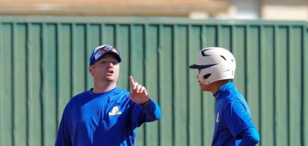First year Bulldawgs coach Dusty Brittain talks with one of his players as they participate in the scrimmage at Gateville High school. BELOW: Brittain watches as the Dawgs take their turn at bat in the scrimmage.