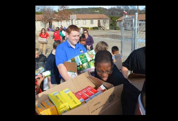 Students at Cove’s Priority Charter School load food they collected for My Brother’s House food pantry.