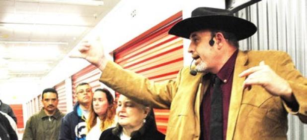 Randy Connor yells out the current bid for a unit at an auction in Patriot Storage. The auction took place Thursday morning where nine units were auctioned off; the highest bid for a unit was $750.