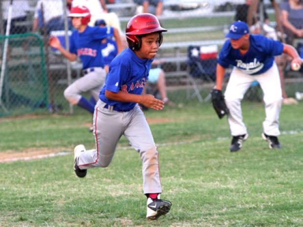 12U Cove Ranger’s Josiah Key charges towards first base as Cove Royals pitcher Austin Hilgenberg makes a play on the ball during their contest Monday as part of the District 4 tournament in.