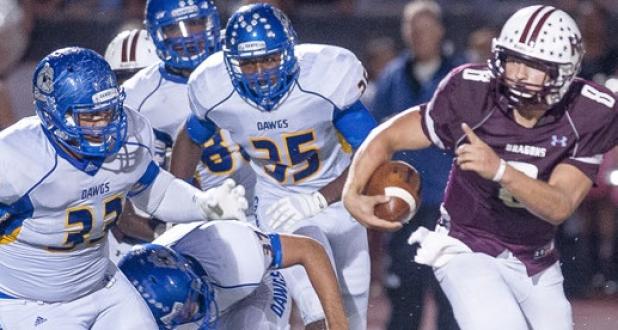 A host of Copperas Cove defenders, led by Phil Aumua (33), pursue Round Rock quarterback Colin Hinson during the Bulldawgs 26-0 loss to the Dragons Friday at Dr. R.L. Peters Jr. Field in Round Rock.