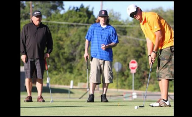 Mike Cataria watches his putt roll towards the hole as teammates Richard ‘Smitty” Smith. left, and son, Kyle Smith look on during the Morning Exchange Club of Copperas Cove’s 16th annual golf tournament.