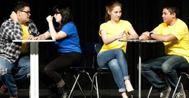 Members of the Improv Done Better troupe carry a conversation in a restaurant setting.