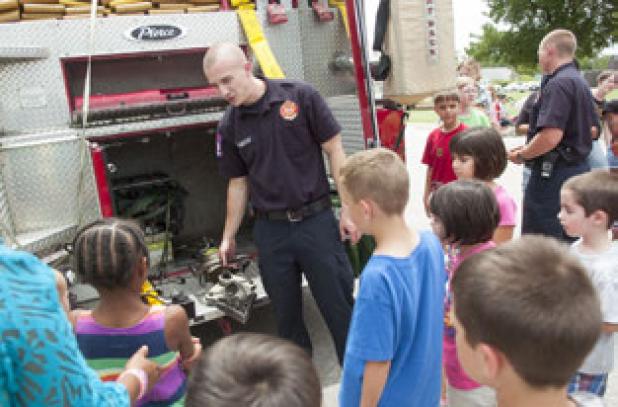Ethan Westbrook shows the Jaws of Life to a group of young readers as they visit the library for Big Trucks day Tuesday.