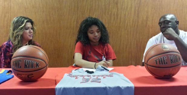 Copperas Cove senior guard Xylina Carlisle, center, with her parents Rose and Orlando Carlisle recently signed a letter of intent to play basketball for the Sul Ross Lady Lobos.