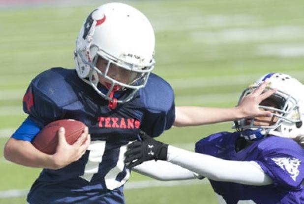 Tackle football players are shown during the 2013 CCYFL championship game. The tackle football program is facing cuts and may be eliminated.