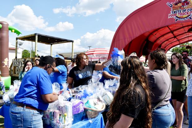 Tasha Roberts, with the Mu Delta Zeta Chapter of Zeta Phi Beta Sorority, and fellow sorority members hand out baskets to mothers at Saturday's community baby shower.