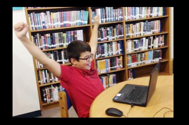 S.C. Lee student Chris Diaz throws up his arms in triumph during the Hour of Code, a computer science module that teachers can implement with existing lessons to teach students computer coding at a young age. Diaz is one of more than one million students who have taken advantage of the STEM-qualified program being offered to schools at no charge.