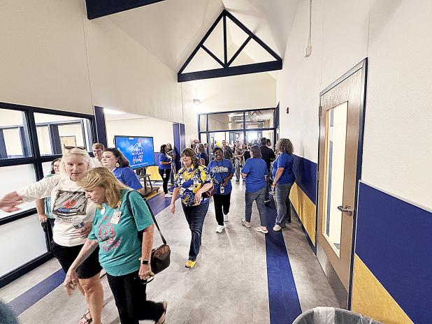 Community members, family, students and CCISD staff enter the newly reopened Williams/Ledger Elementary School after a ribbon cutting on Monday afternoon. 