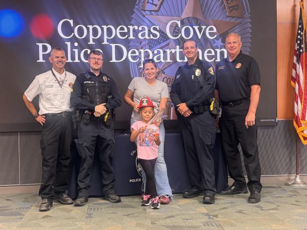 CCLP/LynetteSowell 5-year-old Casia Tucker and her mothere, Casey Gauman, receive challenge coins from both the Copperas Cove Police and Fire Departments for their quick actions to help put out a fire that broke out on the balcony of a nearby apartment on Aug. 2.