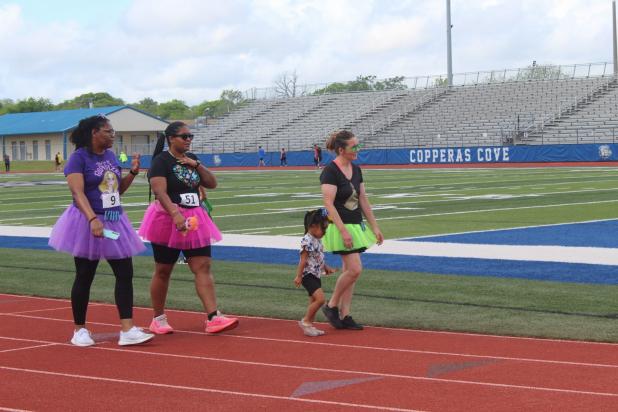 CCLP/BRITTANY FHOLER -- Participants in the Pride of Cove Band & Color Guard’s 3rd annual Marching 5K and Fun Run circle the track at Bulldawg Stadium on Saturday morning. 