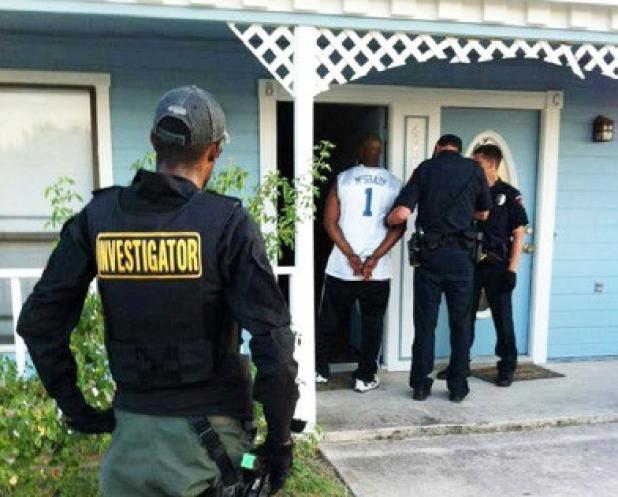 Tremell Pittman (left), private investigator of Peace of Mind watches as police reprimand a unruly husband of suspect he found.