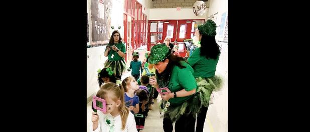 Williams/Ledger Elementary kindergarten students use their “leprechaun finders” which are foam magnifying glasses to hunt for Louie, the leprechaun, and find the pot of gold at the end of the rainbow. – COURTESY PHOTO