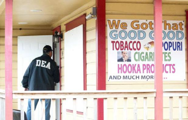 An agent from the Drug Enforcement Agency makes his way into the Smoke Shack in Copperas Cove as he helps confiscate more than $19,000 in cash and $40,000 worth of illegal synthetic marijuana.