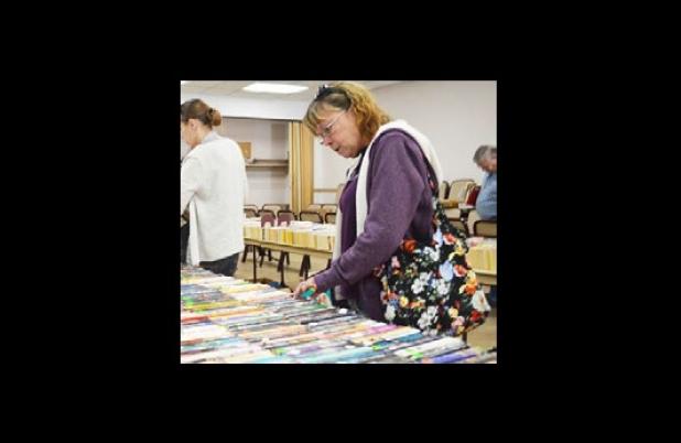 Doreen Ruth browses through the selection of books for sale at the Friends of the Library Saturday morning. Thousands of gently used books were put on sale to help raise funds for new book purchases and the summer reading program.