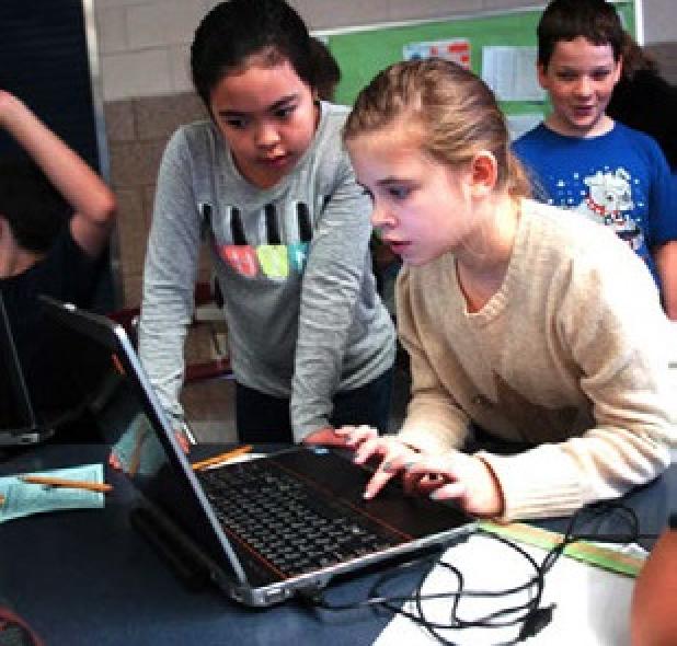 Mikayla Wilson gets help from her team as she programs her robot during the mini-challenge Saturday.