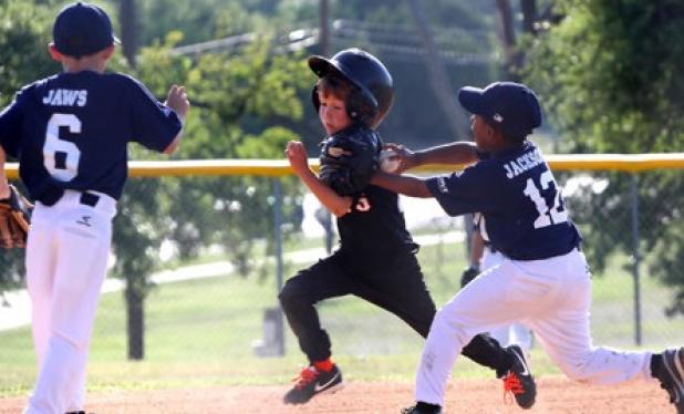 8-under Yankees’ Cameron Jackson tags out Giants Chad Sturdy on his way to third base as Ryan Cox looks on in the second inning of their match up during the 8U Machine Pitch playoffs opening round on Wednesday.