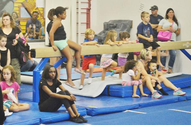 Children of all ages watch the gymnastics demonstration at Saturday’s National Gymnastics Day celebration.