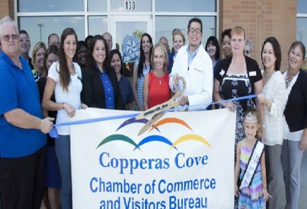 Chamber of Commerce Ambassadors wait with Dr. Daniel Caraveo to cut the ribbon on Benchmark’s offices located in the 5 Hills Shopping Plaza. Benchmark moved to the facility in February after practicing in cove for more than five years.