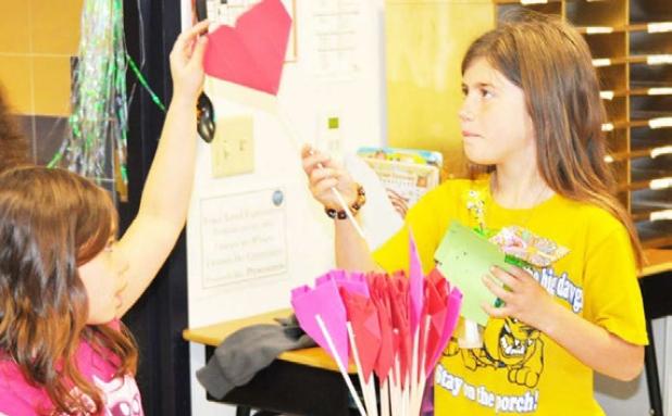 House Creek Elementary School 3rd grader Jenny Edmunds, 9, sells 2-D flower art to a student buyer through the open market project.