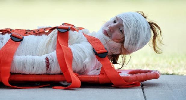 A camper is wrapped and prepared for transport during the 2013 camp. Campers put their knowledge to the test before graduating