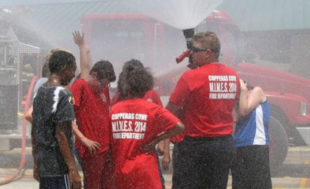 Copperas Cove firefighter/EMT Charles Johnson releases water into the air as he demonstrates the different sprays an attachment can make to the hose while fighting a fire.