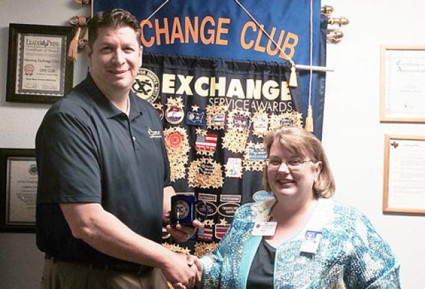 Morning Exchange Club president Mary Derrick presents Parks and Recreation Director Joseph Pace with a coffee cup after he addressed the group, Wednesday morning.