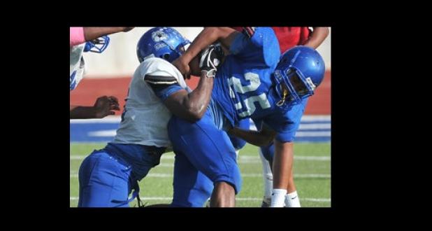 Copperas Cove defensive end Tyrell Thompson drags down running back Trent Canion during the Blue-Gold Spring Game in 2013.