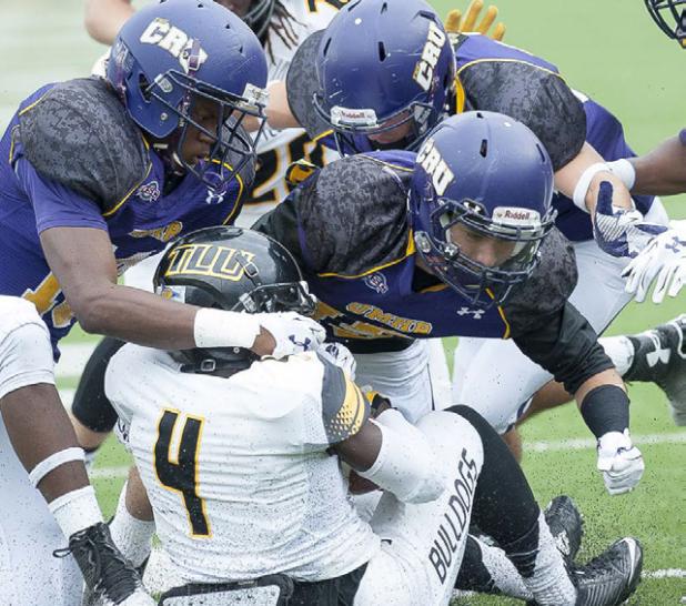 Former Copperas Cove quarterback/receiver Robbie Seybold, center, leads a host of Crusader defenders on a stop of Texas Lutheran’s Demetrius Brock during their contest that spanned two days. The Cru won 27-20.