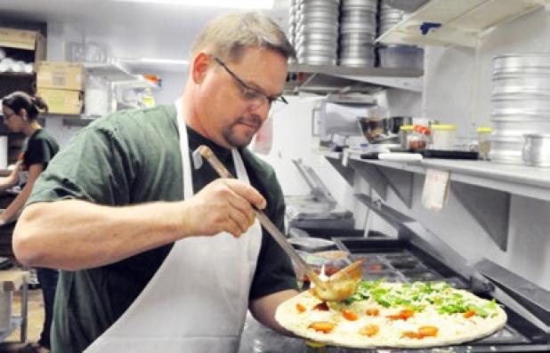 Yaghi’s New York Pizzeria owner, Rod LaBrie prepares a fresh half Margherita and Spinach Roasted Garlic stone baked pizza for ustomers
Tuesday.