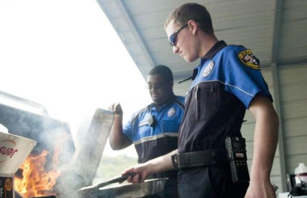 Copperas Cove senior Shawn Noorlun mans the grill as Police Explorers Tyrell Washington and Jason Stanley prepare hamburgers during the cookout funds raiser Saturday at Just Glocks.