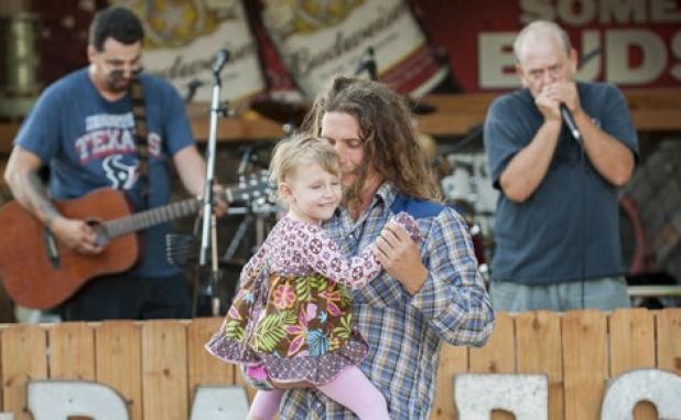 James Wright dances with his daughter Magnolia to the sounds of Justin Bravo & the Kind during a benefit for Texas Angel Tattoos and Rocky Hughes. Wright played with Rust Bucketz and Elution as five bands preformed on the night.