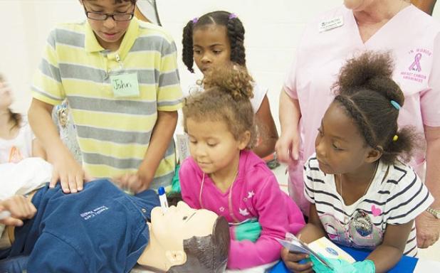Students from Mrs. Dewitt’s class check on a patient at the home health care career booth at Tuesday’scareer day at William Ledger  Elementary.