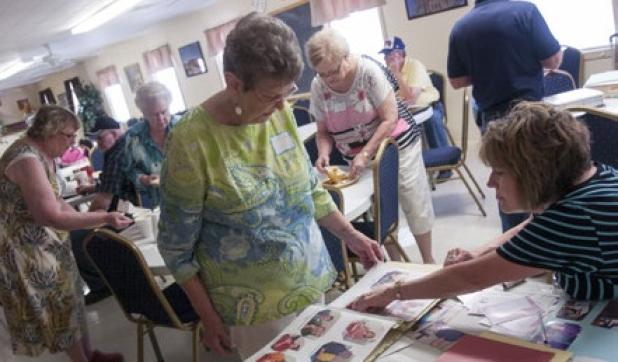 Sandra Kinsey looks over family photos taken from previous reunions during Saturday’s event.