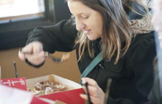 Terra Boynton takes a bite of her fresh Cinnabon ordered during the grand reopening Friday. Boynton was one of the first 100 customers and received a free sandwich a week for a year.